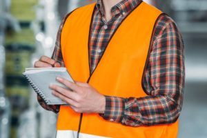 smiling-worker-in-safety-vest-writing-in-notepad-i-BNK875Y